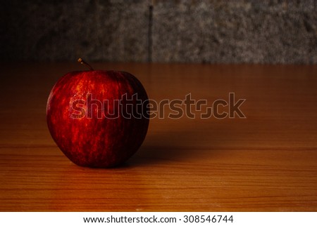 Red Apple on a wooden table with Dramatic lighting, Selective focus.