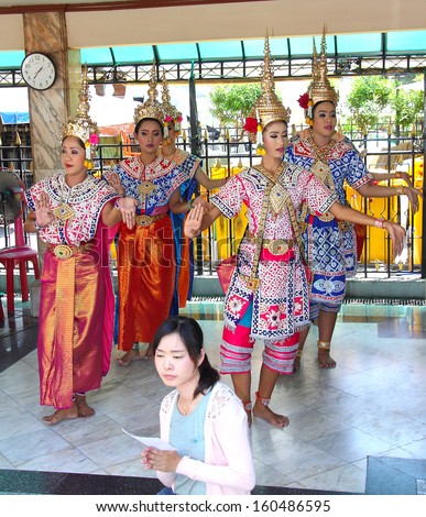 BANGKOK, THAILAND - MARCH 23, 2013: A group of smartly dressed Thai dancers in the city center of Bangkok at the Erawan Shrine. People come here to pray for good lottery luck.