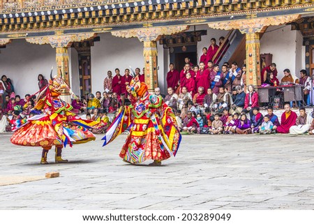 PUNAKHA, BHUTAN - MARCH 8, 2014: Two masked dancers at  drupchen festival in the dzong of Punakha, Bhutan. Drupchen festival is taking place yearly in march.