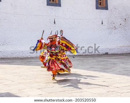PUNAKHA, BHUTAN - MARCH 8, 2014: masked dancers at  drupchen festival in the dzong of Punakha, Bhutan. Drupchen festival is taking place yearly in march.