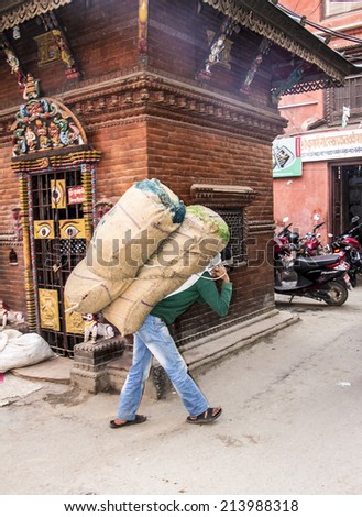KATHMANDU, NEPAL - MARCH 23, 2014: Many goods in kathmandu are still carried on the back through the narrow streets.