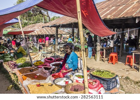 NIAUNGSHWE, MYANMAR - FEBRUARY 2, 2015: A market vendor at a market at the bank of the famous lake Inle, Myanmar