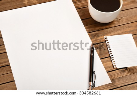 White paper with cup of coffee on wooden table