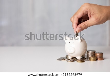 Hand putting a coin on pig saving. a pile of coins, business, investment, finance, and Money Saving for future concepts, save money. Сток-фото © 