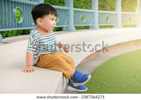 Similar – Image, Stock Photo Baby legs dangling from high chair; baby wearing turquoise outfit with bare feet against white wood background