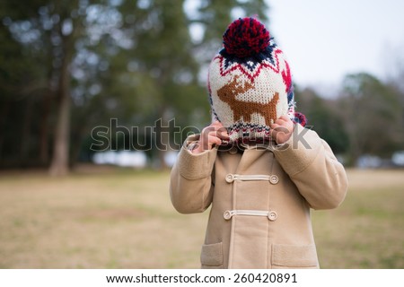 Girl hide her face with knit hat