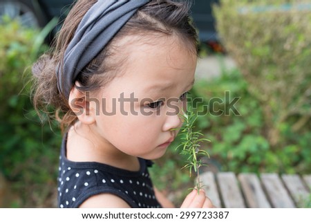 Girl to smell the scent of rosemary