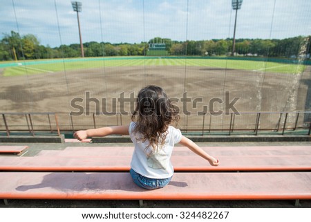 Girl sitting in the baseball field of the stand