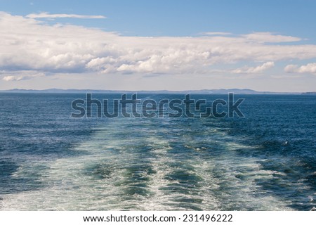 Large wake on blue open ocean left by a large ferry boat