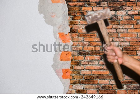 breaking brick wall with hammer