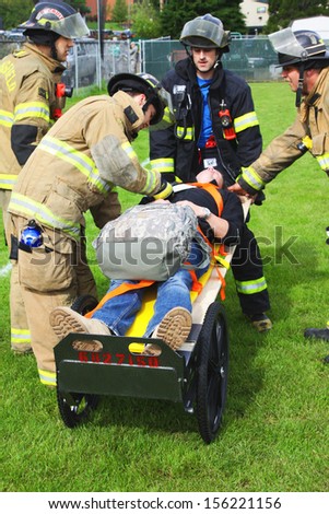 Eugene, Oregon, USA Â?Â? May 2, 2012: Eugene, OR Emergency Services and National Guard work in a disaster response drill. The unidentified firemen are transporting unidentified injured to landing zone.