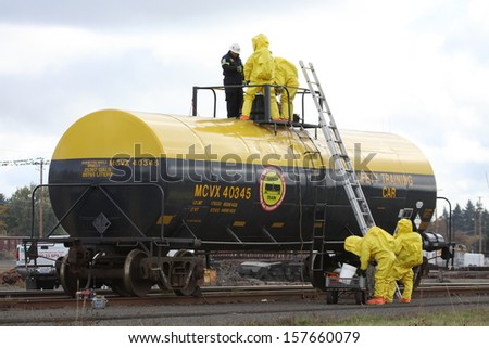 EUGENE, OREGON, USA  November 3, 2011: Eugene fire departments and emergency teams conduct disaster drills. HAZMAT team is passing tools up to team members on the rail tanker to repair it.