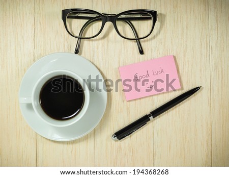Good luck cards with glasses and cup of coffee on wooden desk.