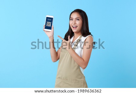 Entrepreneur asian woman showing smartphone scan QR code for payment on blue background.