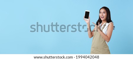 Entrepreneur asian woman showing blank screen smartphone on blue background. panoramic background.