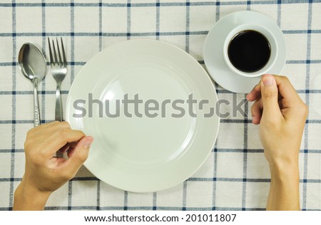 Man sitting at the dinner table and coffee and empty plate