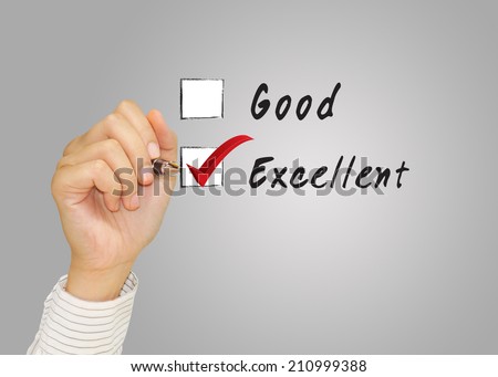 Hand putting check mark with red marker on excellent credit score evaluation form.