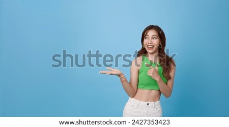 Young pretty asian girl with cute face inflates the chewing bubble in glowing pink neon light of the city at night. Hipster teenager concept.