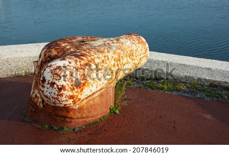 Large metal Bollard on ocean pier.
