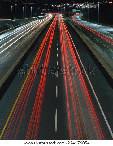 Car trails on a busy highway at night.