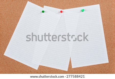 Three sheets of ruled note paper pinned on cork board.