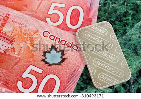 PLEASANT VALLEY, CANADA - AUGUST 27, 2015: Top down detail view of Canadian 50 dollar bills and Engelhard  silver bar.