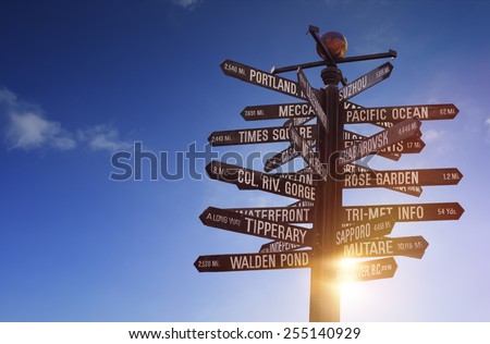 World Landmarks Signpost containing various famous places all over the world, with blue sky, sun shining through the object and free copy space for your text