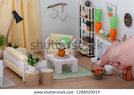 Lovely bright interior of a doll house living room with lite rustic furniture, A woman decorating the dollhouse with a basket Сток-фото © 