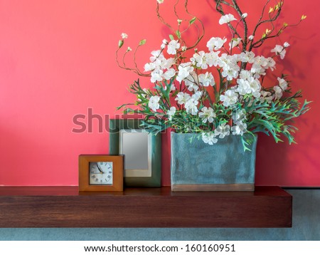 Pink modern interior wall with artificial flowers in ceramic vase