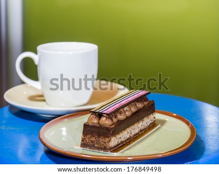 Cup of coffee and slice chocolate short cake decorate with colorful stripe