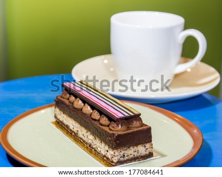 Cup of coffee and slice chocolate short cake decorate with colorful stripe