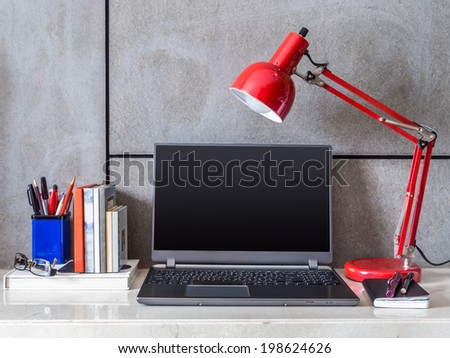 Modern home office desk with laptop and lamp