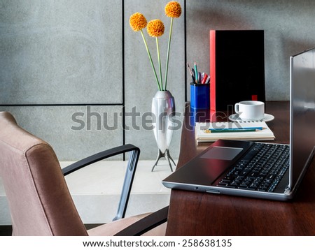 Modern workplace with laptop computer and flower vase on desktop