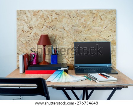 Modern creative workspace with computer / compressed plywood chipboard wall background