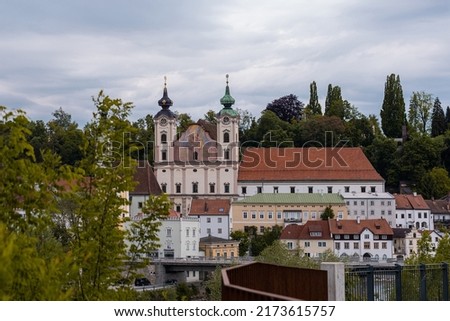 Panorama or cityscape of a church in steyr, austria, rising above the enns river in cloudy weather. Austrian panorama of a city in the steiermark region. Photo stock © 