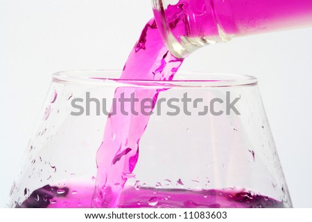 Purple Liquid Pouring From A Bottle To The Glass On Grey Background ...