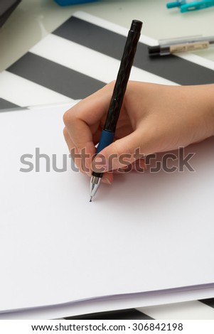 Close up on an asian girl\'s hand taking note