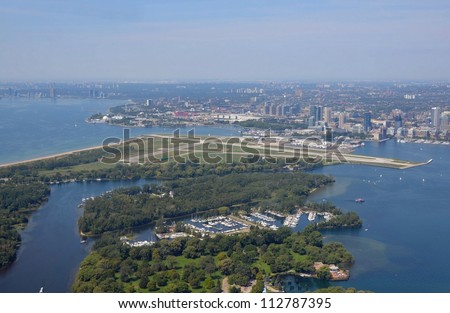 aerial view of the Toronto Island Park Deep Pike Cut and Mugg\'s island, Billy Bishop Airport and Toronto Skyline in the background