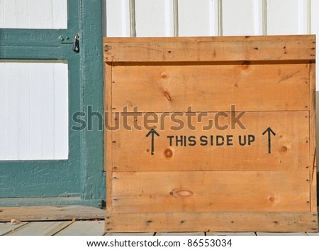 wooden shipping crate with this side up writing