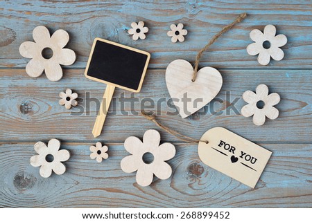 blue grey background with wooden hearts and flower and with love, for you label and chalkboard