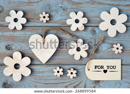blue grey background with wooden hearts and flower and with love, for you label