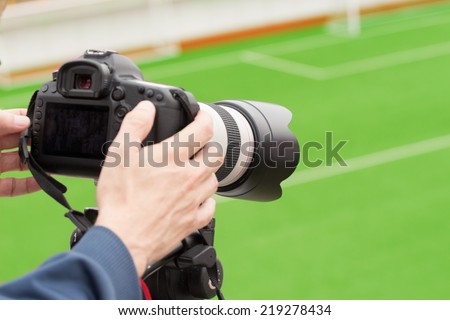 Cameraman recording sports event.