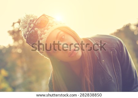 Smiley girl in a park with sun flare.