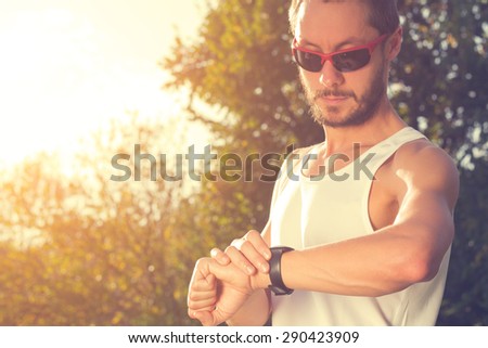 Jogger checking his running time in the park.