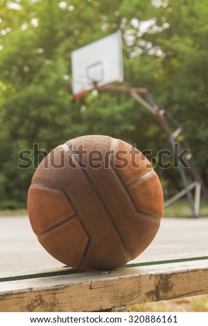 Basketball ball on a bench with defocused playing field.