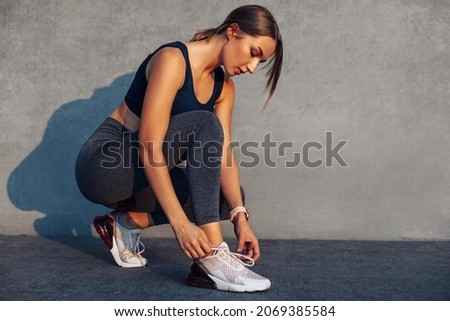 Similar – Image, Stock Photo Sporty woman tying laces on sneakers before training