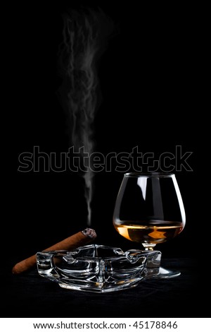 Snifter glass of cognac and cigar