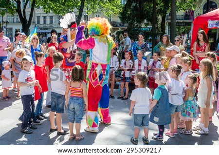 Lviv, Ukraine - July 2015: Yarych street Fest 2015. Clown and Indian play, sing and dance with the children in the park