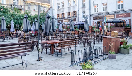 Lviv, Ukraine - September 2015: Street cafe with empty tables and chairs with umbrellas with colorful lights in the historic city of Lvov