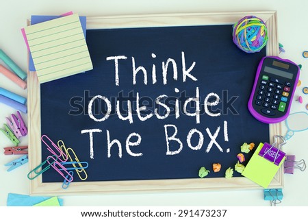 Think outside the box motivational note on chalkboard background concept